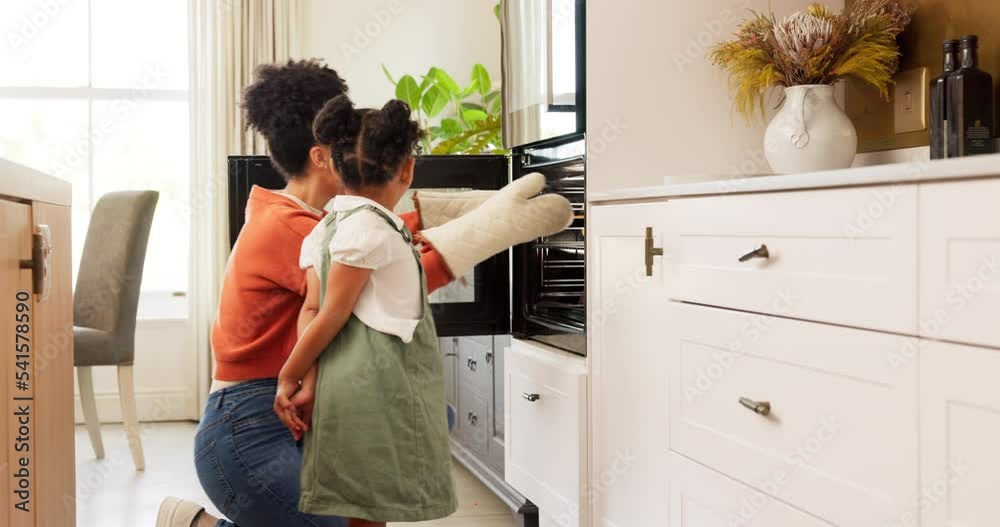 Mother, child and cooking together in home smelling of cookies after baking in oven of kitchen learning about food activity. Black woman and kid family happy about helping with lunch in UK house Mother, child and cooking together in home smelling of cookies after baking in oven of kitchen learning about food activity. Black woman and kid family happy about helping with lunch in UK house
