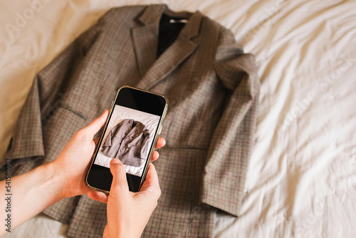 Close-up of woman's hands taking picture of the jacket. photo