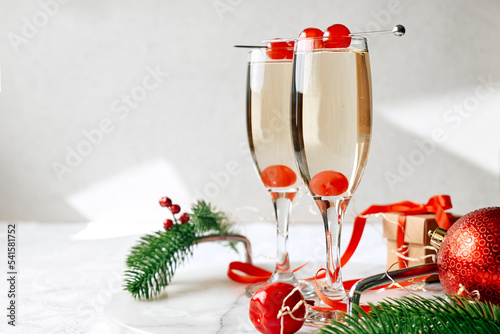 Christmas cocktail with sparkling wine decorated with cherry. Winter xmas and new year holidays champagne drink.