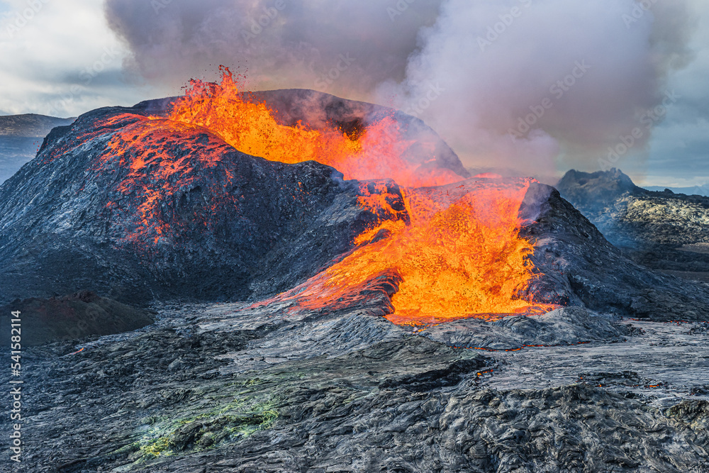 active volcano with strong lava flow. Volcano crater in iceland at time of eruption. Volcanic landscape on Reykjanes Peninsula in GeoPark. View of crater with heavy smoke development active volcano with strong lava flow. Volcano crater in iceland at time of eruption. Volcanic landscape on Reykjanes Peninsula in GeoPark. View of crater with heavy smoke development