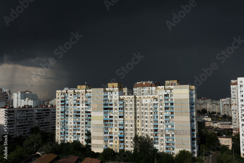 Black rain clouds in the sky above high-rise residential buildings. Stormy weather in the city. Rain and dark clouds. bad weather Scary sky.