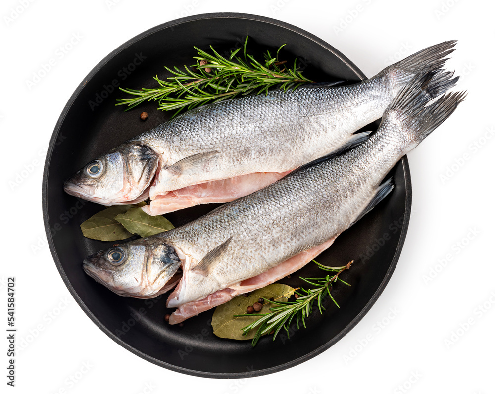 Sea bass fish. Two peeled raw sea bass, spices and rosemary branches in a skillet Sea bass fish. Two peeled raw sea bass, spices and rosemary branches in a skillet
