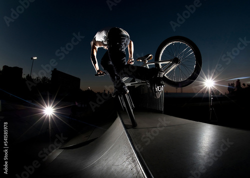 Fotografering boy with his BMX bike at dusk at a skatepark