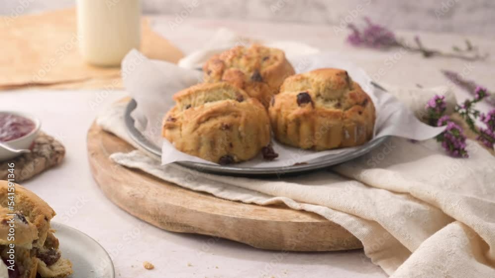 Scones with Strawberry Jam and Clotted Cream with milk served on glass bottle on white kitchen countertop. Scones with Strawberry Jam and Clotted Cream with milk served on glass bottle on white kitchen countertop.