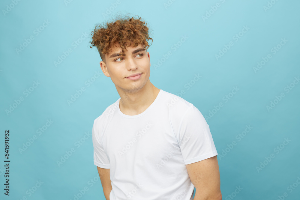 horizontal isolated portrait of a handsome man with curly hair smiling pleasantly looking to the side, standing in a casual white T-shirt posing relaxed horizontal isolated portrait of a handsome man with curly hair smiling pleasantly looking to the side, standing in a casual white T-shirt posing relaxed