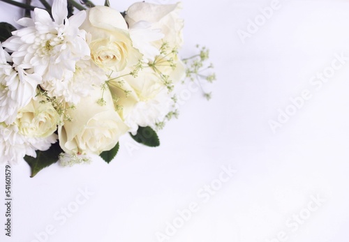 White roses and white chrysanthemums on a white background. Festive flower arrangement. Background for a greeting card. © Olirina
