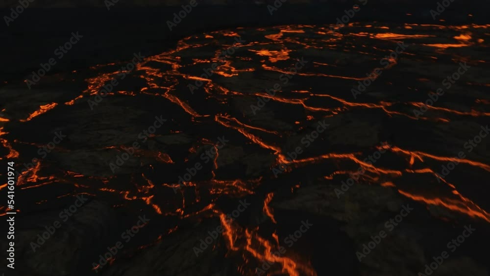 FPV drone shot low over bubbling volcanic rock and a large glowing magma field