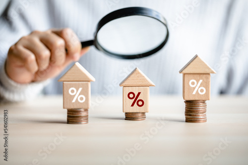 women customer using magnifying glass finding to interest rate home is minimum, affordable alternative price, mortgage home, financial and investment concept. photo