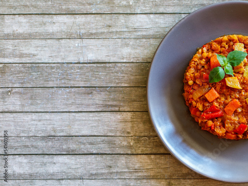 Wallpaper Mural Healthy vegetarian homemade lentil stew with vegetables on a plate with basil leaf on rustic wooden table. Vegan diet. Top view, flat lay, copy space Torontodigital.ca