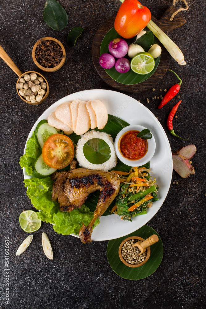Ayam Bakar or Roasted Chicken with herb and spice from Indonesia, served on white Oval plate 
