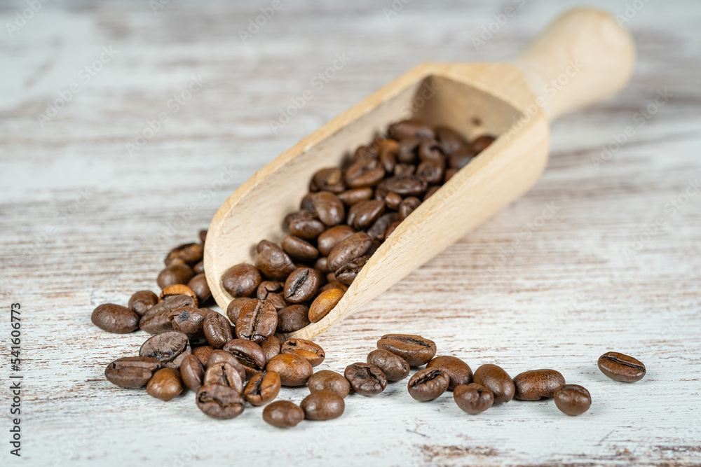 Obraz premium Wooden spoon with coffee beans ready to grind and enjoy their flavor.