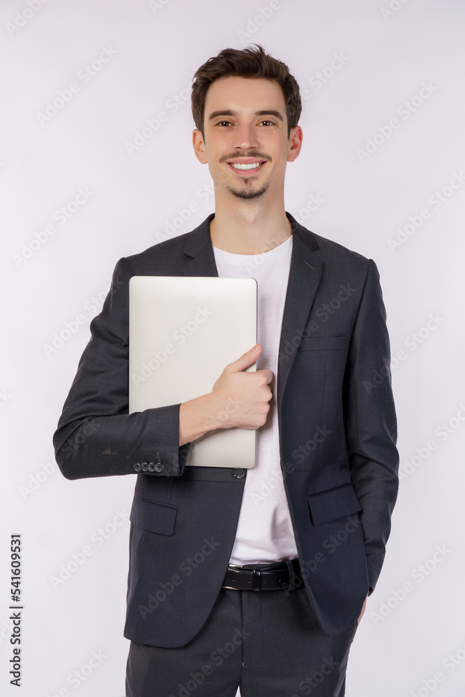 Portrait of young businessman happy positive smile holding laptop isolated over white background Portrait of young businessman happy positive smile holding laptop isolated over white background