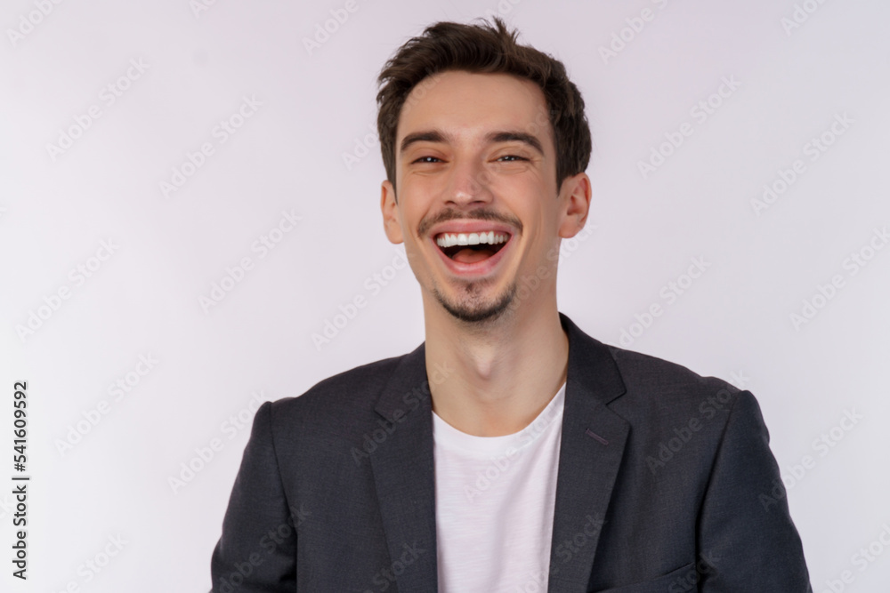 Portrait of happy cheerful young man laughing and looking straight at camera isolated over white background Portrait of happy cheerful young man laughing and looking straight at camera isolated over white background