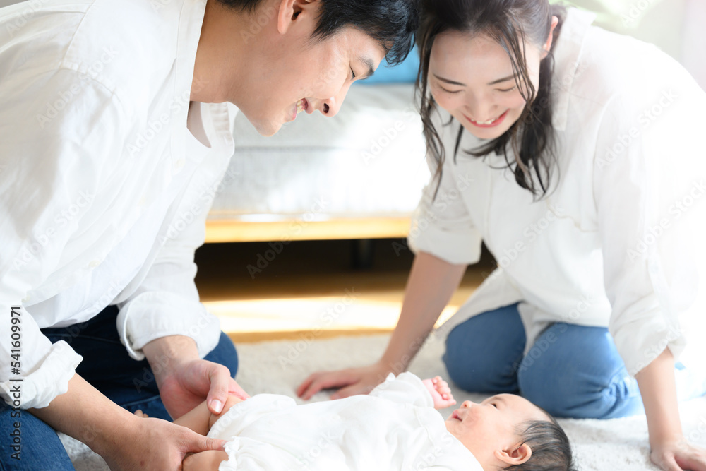 Obraz premium 赤ちゃんをあやすアジア系のお母さんとお父さん