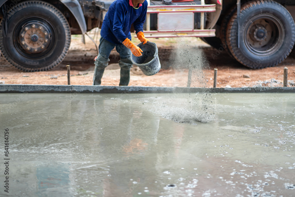 Construction workers in Asia are pouring plaster and mortar to polish cement floors. Construction workers in Asia are pouring plaster and mortar to polish cement floors.