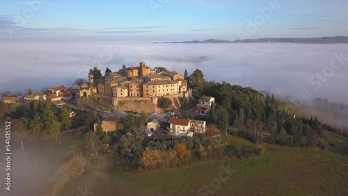 Aerial slow movement around medieval village of Arcevia surrounded by buildings photo