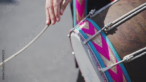 Close-up playing an oriental musical instrument Dhol. Stick hits the drum
