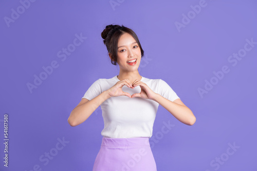 Portrait of a beautiful Asian woman posing on a purple background