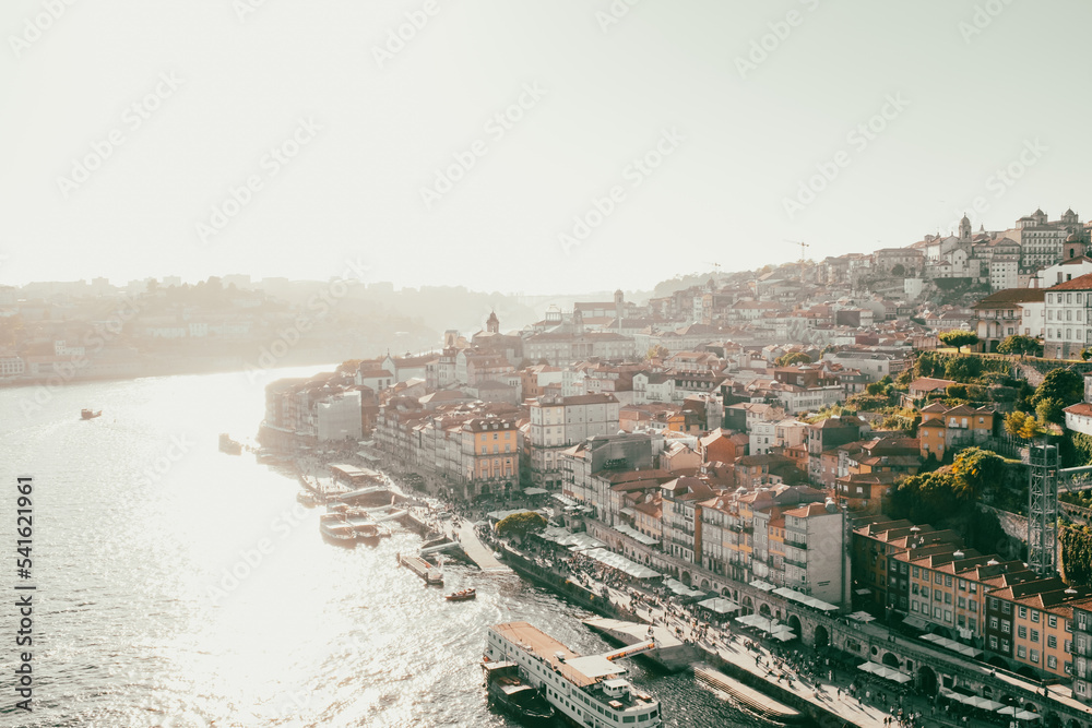 Porto cityscape over the River Douro shore with the sun shining and flare on a summer day