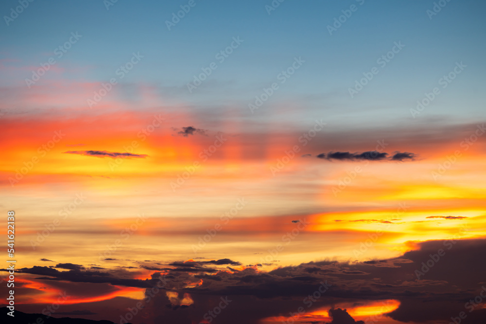 Fototapeta premium The dramatic colors of the sunset in the sky gradient from blue to orange.