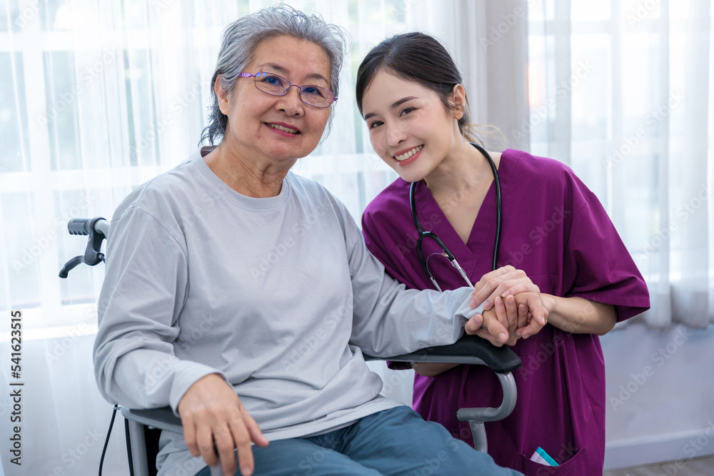 Obraz premium Caregiver nurse take care a Senior patient sit on wheelchair. Nurse helping senior Woman