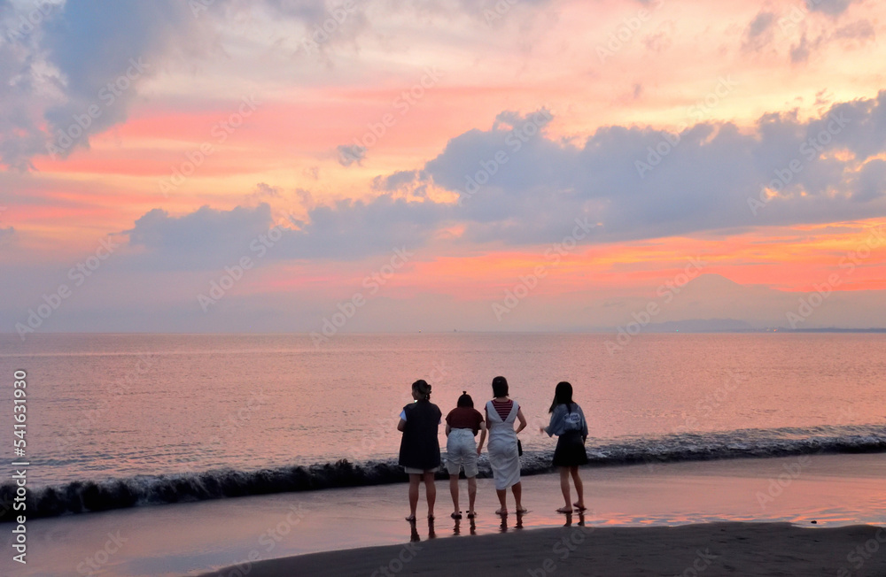 片瀬西浜海岸で沈む夕日を眺める人々