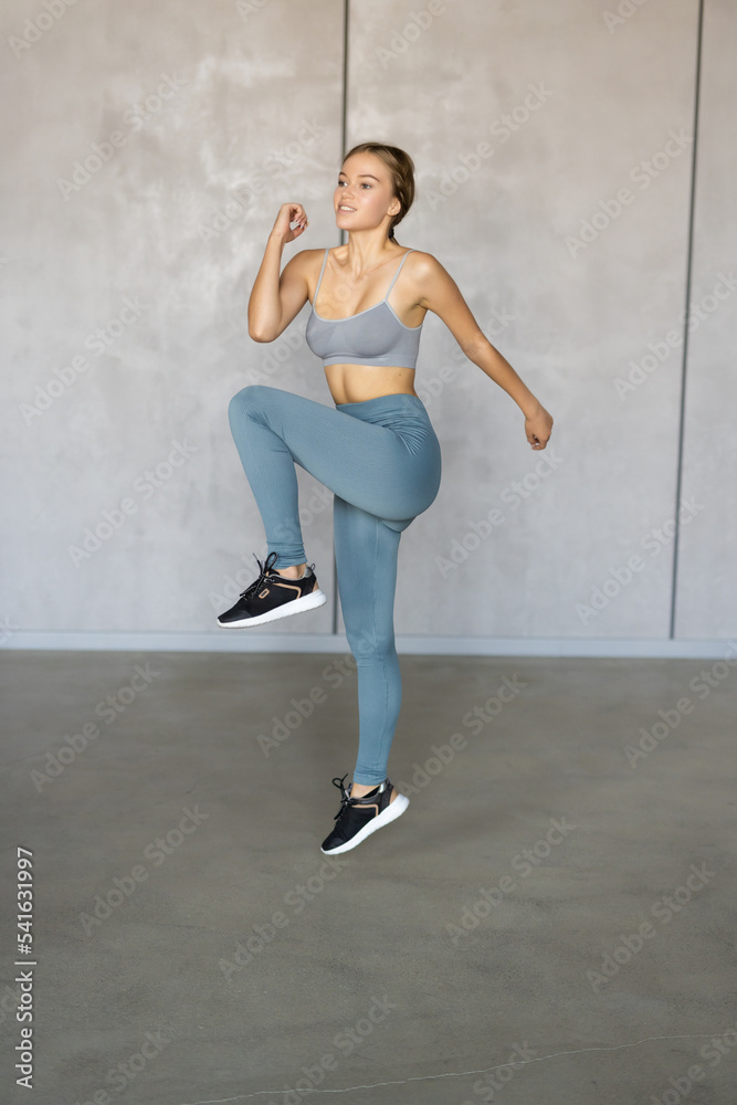 Young fit woman doing fitness exercises in front at home