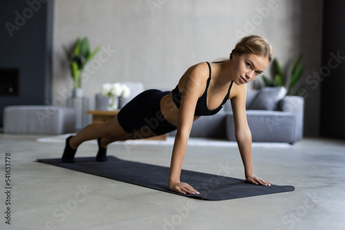Slim fitness young woman doing plank exercise at home concept training workout crossfit gymnastics cross fit.