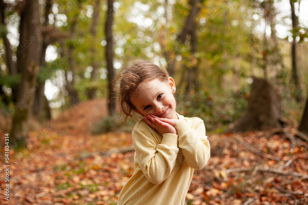 Little blonde girl in a yellow sweatshirt on a walk in autumn Little blonde girl in a yellow sweatshirt on a walk in autumn