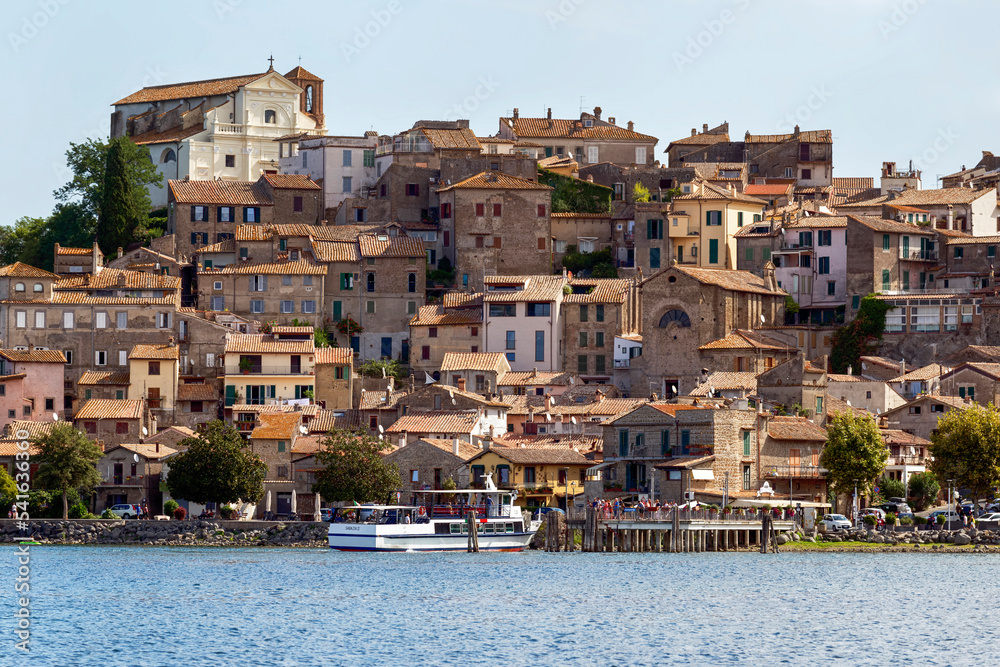 On the shores of Bracciano Lake the beautiful sky line of the picturesque medieval village of Anguillara Sabazia located in the Lazio region, Italy