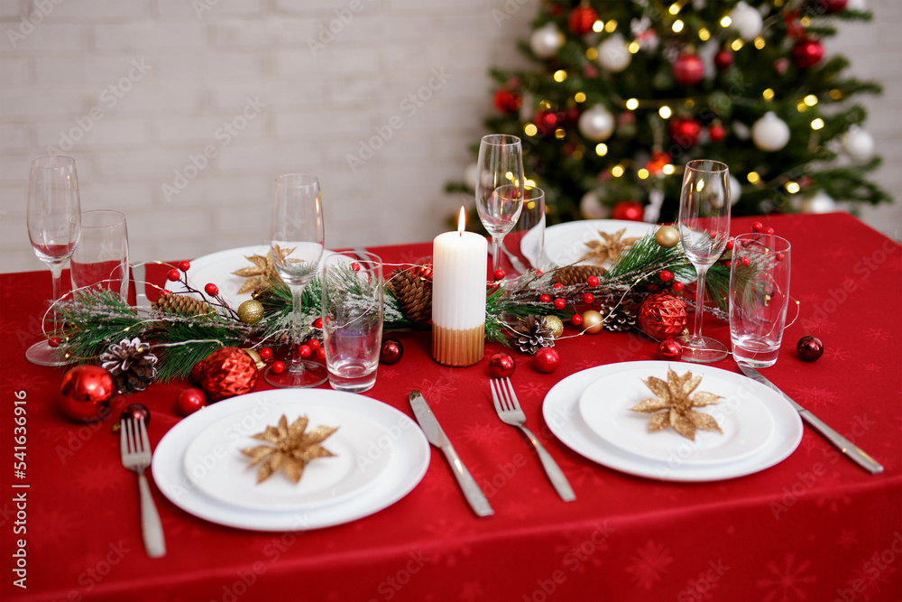 Served table for christmas dinner with plates, forks, knifes and glasses Served table for christmas dinner with plates, forks, knifes and glasses