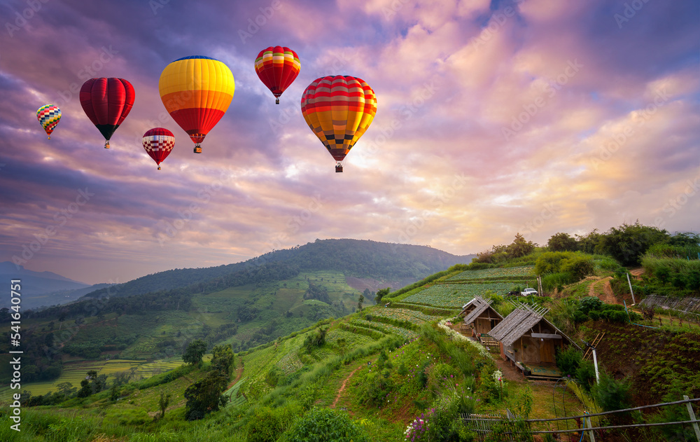 Colorful hot air balloons flying over mountain in sunrise at Khun Pae, Chiang Mai, Thailand.