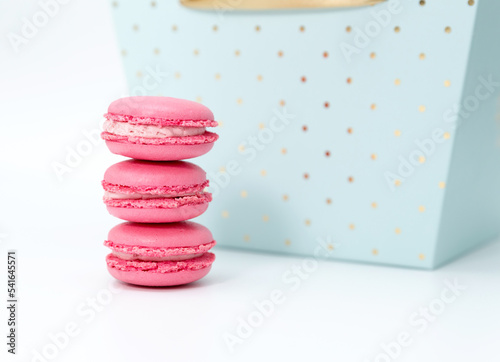 Three pink macaroons on the background of a blue box