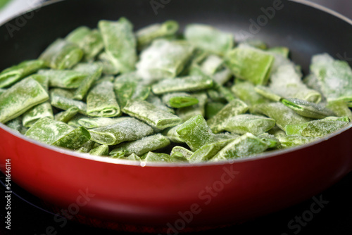 Frozen green beans in a pan ready for cooking. Vegetable preservation. Selective focus