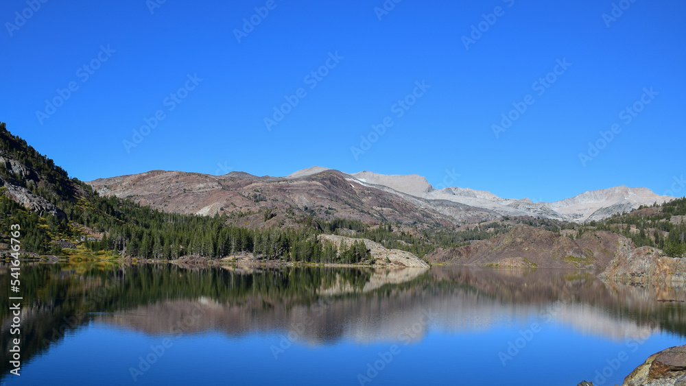 a lake with simetrical reflections and blue sky