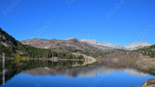 a lake with simetrical reflections and blue sky