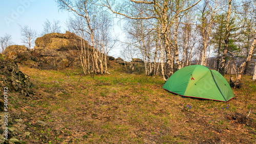 tourist tent stands in the forest on the irendyk ridge in the southern Urals on a spring sunny day