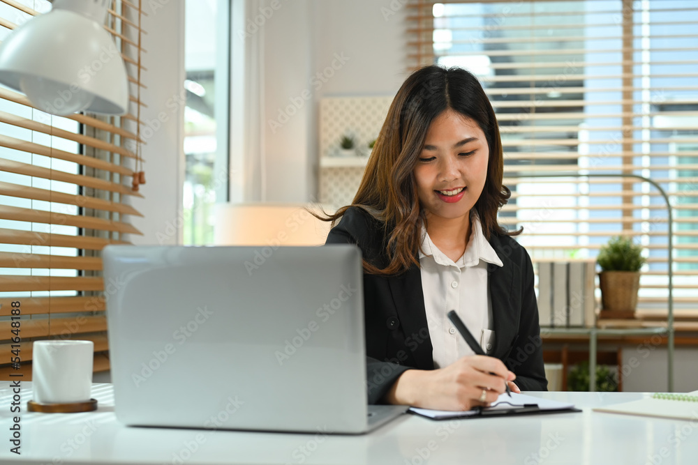 Smiling young woman investor working on commercial and marketing project at her office Smiling young woman investor working on commercial and marketing project at her office
