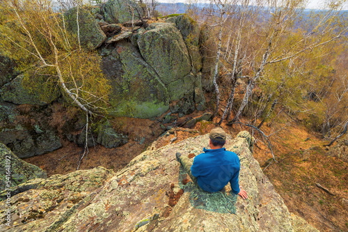 mature male Tourist resting on a rock on the irendyk ridge in the southern Urals in early spring