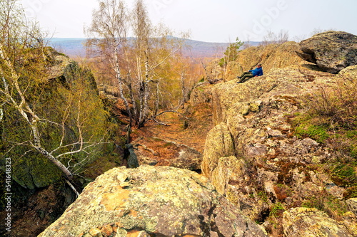 mature male Tourist resting on a rock on the irendyk ridge in the southern Urals in early spring