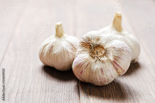 Garlic bulbs on a wooden background. Copy space.