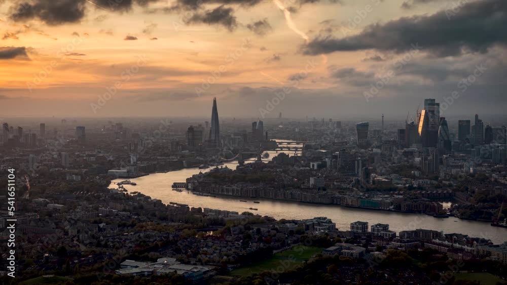 Autumn sunset time lapse of the cityscape of London, England, with moody clouds and sunshine over the skyscrapers and river Thames