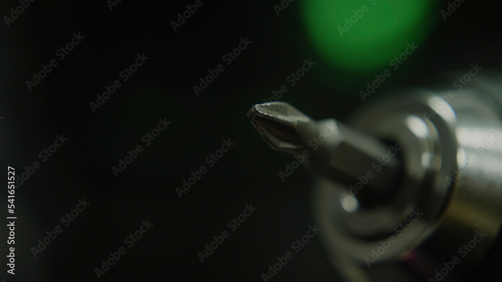 Rotating drill bit flat or cross recess head, macro extreme close-up, technology and toolkit concept Rotating drill bit flat or cross recess head, macro extreme close-up, technology and toolkit concept