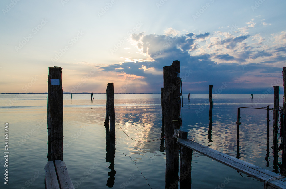 Il crepuscolo con le nuvole che si riflettono nelle acque calme della laguna di Venezia visto dall'isola di Pellestrina