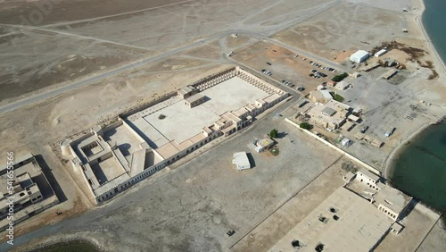 A camera drone fies around Aqeer (Al Uqayr) Castle, Saudi Arabia photo