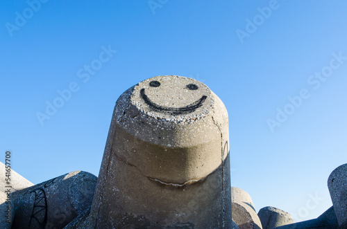 Uno smile dipinto su un frangiflutti di cemento