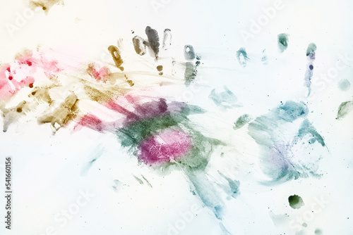 Color splash and multicolored handprints on white background, blue cold tone