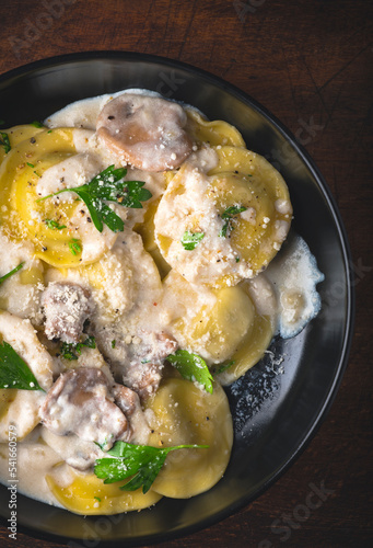 Ravioli with mushroom creamy sauce and mushroom stuffing with herbs and ground pepper. Winter recipes for the cold season of Italian cuisine