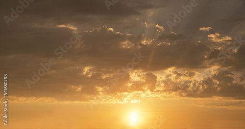 golden sunset scenery with grey clouds above, after thunderstorm