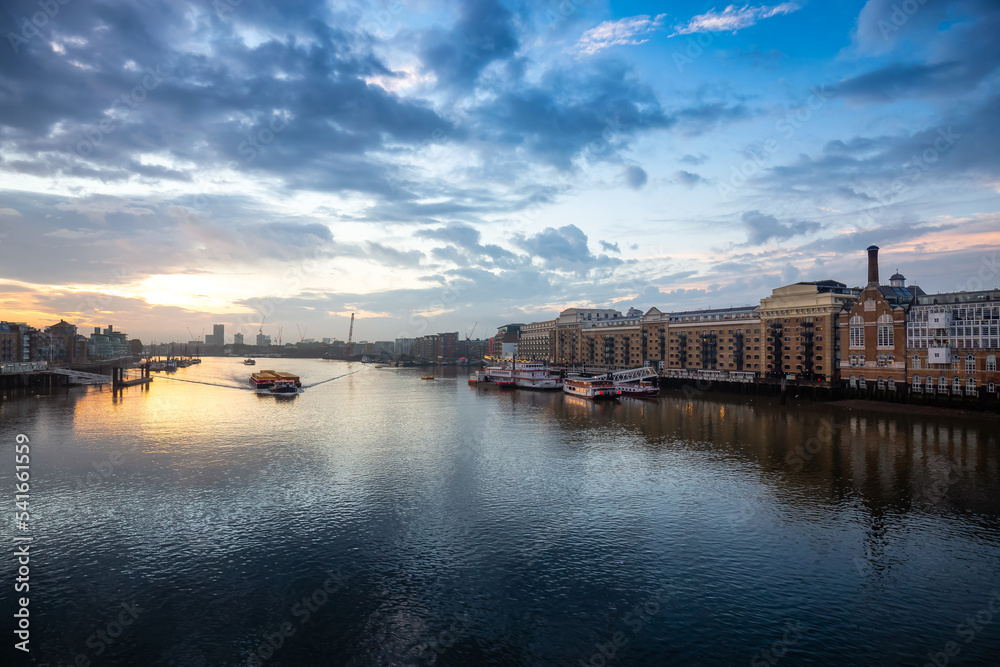 View of River Thames and City Skyline during dramatic sunrise. City of London, United Kingdom. Travel Destination